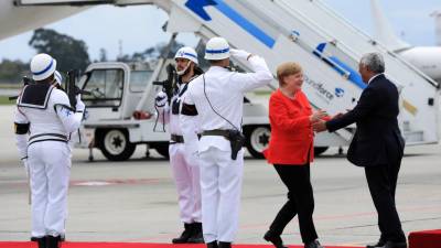 Angela Merkel troca sorrisos e acenos com alguns curiosos na chegada a Braga