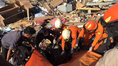 Autoridades indonésias abrem vala comum para enterrarem os mortos do sismo e tsunami