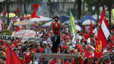 Manifestantes de vermelho levam 1.º de Maio à prisão onde está Lula